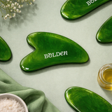 Green jade gua sha tools with 'Bolden' branding on a light green background with flowers.