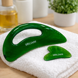 Green gua sha tools on a white towel with 'Bolden' branding.